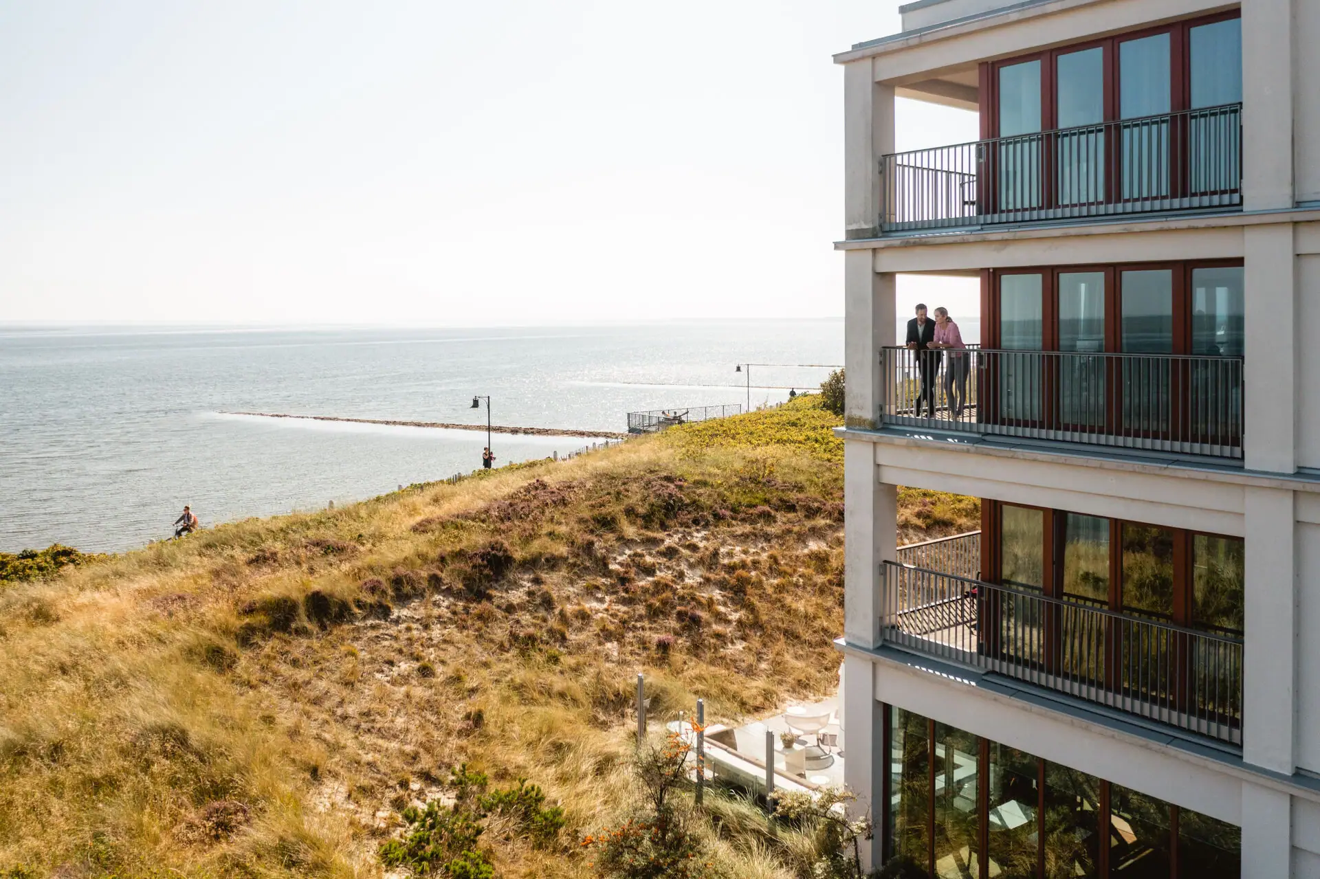A-ROSA Sylt Un grande edificio vicino a uno specchio d'acqua.